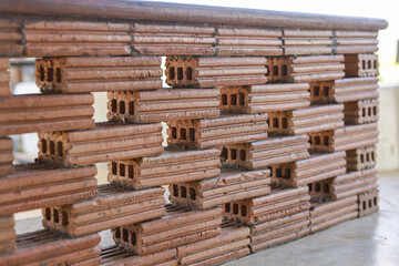 Unique brown brick wall construction featuring hollow rectangular pattern and strong solid structure with textured surface outdoors conveying stability and classic architectural craft