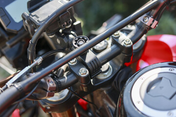 Fototapeta premium Close up shot displaying detail of red motorcycle handlebar fuel tank cap and sturdy metal mount evoking feeling of freedom and adventurous journey with classic motorbike transportation part