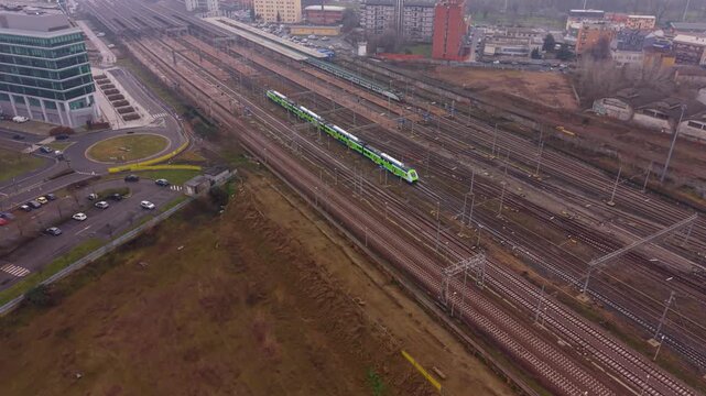 Train Tracks Aerial View: A train travels along a series of tracks, cutting through an urban landscape, offering a unique perspective from above. 