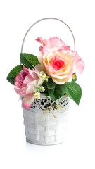 Pastel pink roses in a small white basket with a metal handle, against a bright white background