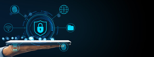 Hand holding tablet with cybersecurity interface icons including fingerprint, lock shield, and global network on dark digital background.