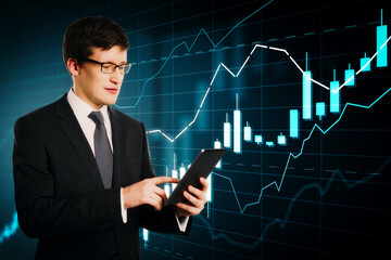Businessman using tablet with stock market candlestick chart and analytics data on digital screen in modern financial trading concept background.