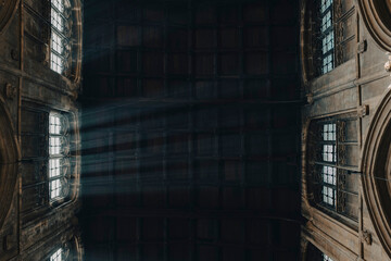 Rays of light entering through a window in a gothic Church with a wooden ceiling in the Cotswolds, England