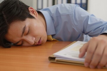 Naklejka premium Man sleeping at desk in office
