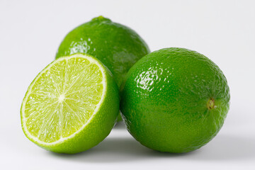 Fresh lime fruit cut in half isolated against white background, close up detail.