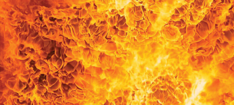 Seamless motion loop of a hot fiery inferno with burning orange flames and red energy texture creating a glowing explosion design on a dark background