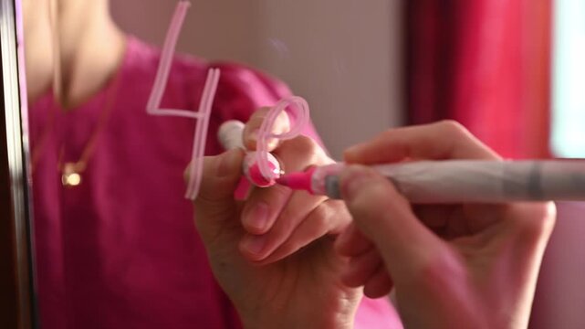 Love note.  A girl writes the word &ldquo;4ever&rdquo; on a mirror, symbolizing lasting love, commitment, and youthful expression of romance. 