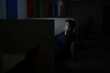 Fototapeta premium Man in office cubicle on phone