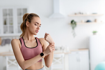 Self-training and trauma at home. Woman feeling pain in arm after exercising at home. Sad young...