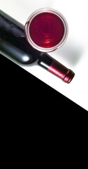 
A glass and a bottle of red wine on a white background. Black background for text.