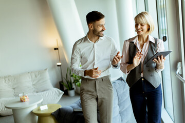 Obraz premium Colleagues discuss project ideas while walking in a modern office setting