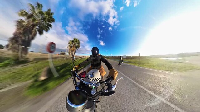 Chico con casco oscuro en motocicleta cl&aacute;sica rodando por carretera y bosque en d&iacute;a soleado ,toma grabada en 4k