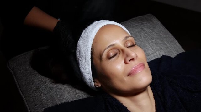 Relaxed client enjoying facial microcurrent treatment aimed at revitalizing skin enhancing circulation and improving overall facial brightness.