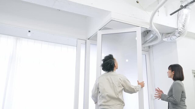 ガラスパーティションを修理する作業員