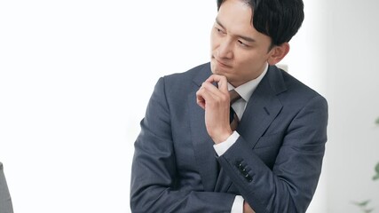 考える男性ビジネスパーソン