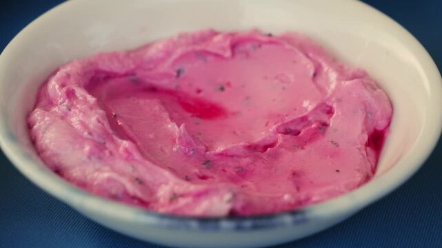 Yogurt sauce with the addition of grated beets and spices, close-up. High quality 4k footage