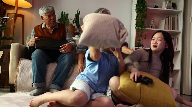 teasing. sisters and brothers are having fun teasing each other. Asian sibling having fun playing game. Happy Family leisure activity with parents and children playing video game living room at home