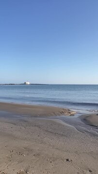 Vertical view of Agios Nikolaos Church in Georgioupoli, white chapel in the sea, calm water and sunny weather, Crete