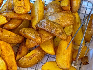 Crispy Golden Fried Potato Wedges on a Cooling Rack.