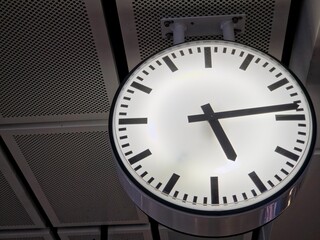 Large Circular Industrial Station Clock Mounted on Perforated Ceiling