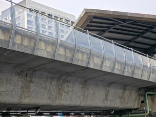 Modern Elevated Railway Bridge with Glass Sound Barriers and Urban Backdrop