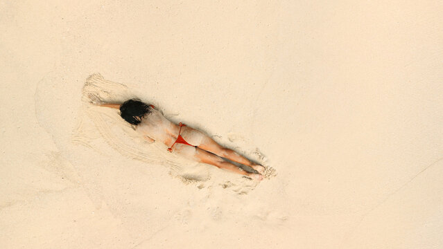 Aerial View Of Topless Woman Relaxing On Beach In Red Bikini Bottoms