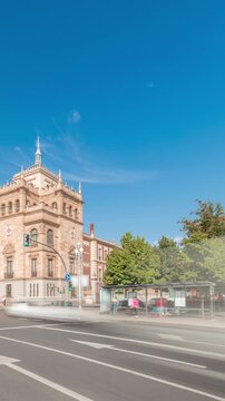 Panorama showing Cavalry Academy timelapse in Plaza de Zorrilla, Valladolid, Spain. Historic military building with intricate architecture, surrounded by busy urban scene under a blue sky with clouds