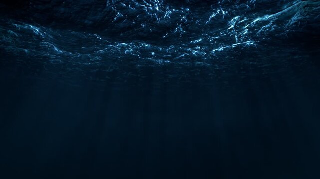 View of the ocean waves from under the water. Seamlessly looped video. Dramatic blue lighting and light rays.