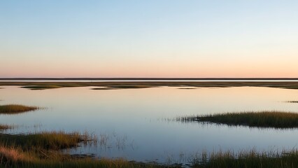 Obraz premium Tranquil coastal marsh landscape at twilight, with calm waters reflecting the serene pastel sky and scattered patches of golden marsh grass