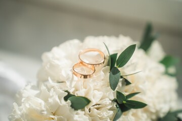 Wedding rings on the wedding bouquet of white roses