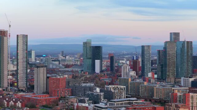 Aerial video of Manchester city center skyline, showcasing the Deansgate Square towers and the ongoing high-rise construction at sunset.