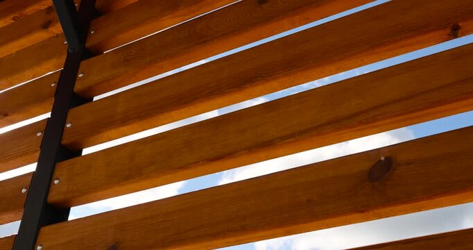 a wooden frame made of logs and planks on the beach in sunny weather against a blue sky with clouds, part of a wooden frame building under construction on the beach to create a good infrastructure