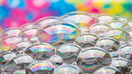 Soap foam bubbles macro texture with iridescent rainbow reflections.