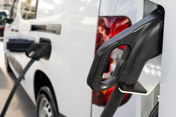 Obraz premium Electric delivery van with electric vehicles charging station