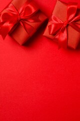 Festive gift boxes with red bows on color background. St.Valentine's Day