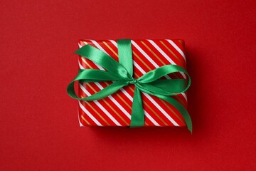 Beautiful Christmas gift box with ribbon on red background