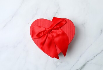 Festive gift box with red bow on marble background. St.Valentine's Day