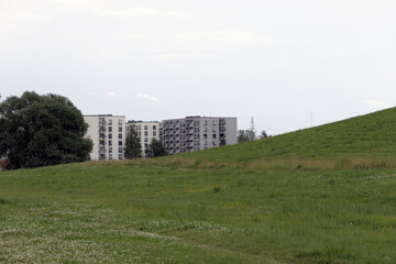 Fototapeta premium Modern Apartments Behind Grassy Slope