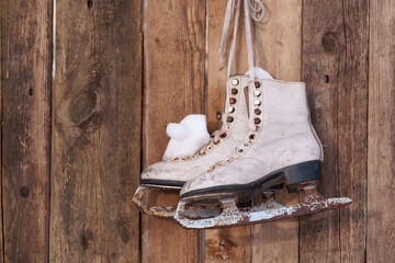old skates hanging on a plank wall © talavietis