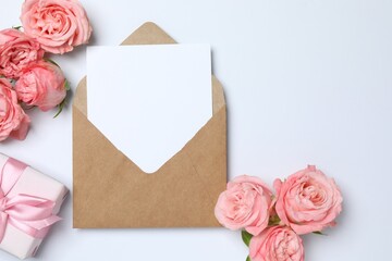 Saint Valentine's Day concept. Top view photo of open envelope with paper sheet and pink peony roses on isolated white background with copyspace