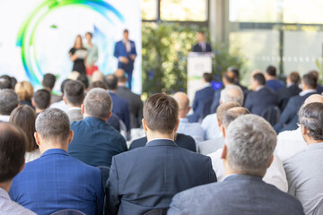 Business conference audience listening to speaker on stage, corporate seminar event, professional networking and leadership presentation indoors