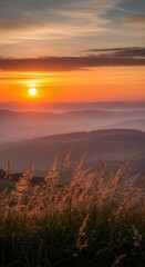 Obraz premium Sunset over mountain layers with grass foreground
