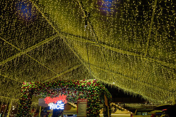 Naklejka premium Canopy of golden Christmas lights illuminating the Naughty or Nice, Distillery District, Toronto, Canada