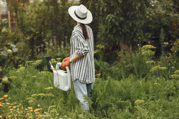 Women pours flowers in the garden with watering can