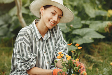 Woman in a hat gardening in her backyard