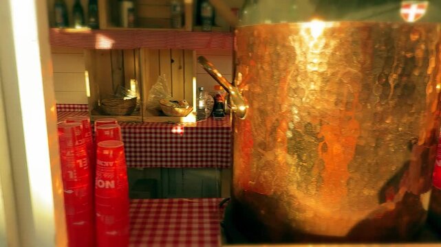 Vendors selling traditional mulled wine and hot cider in copper pots at the Annecy Christmas market, France