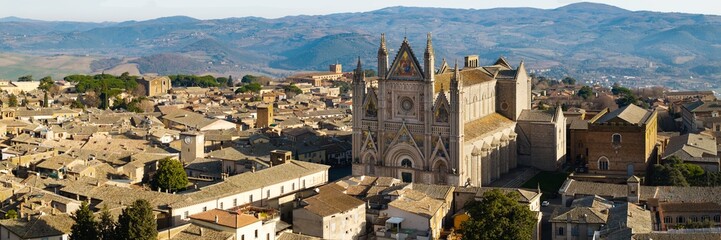 Obraz premium Detailed Aerial Panorama of Orvieto Duomo and Historic Rooftops: Italian Gothic Cathedral against Apennine Mountains Backdrop, Umbria Italy