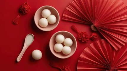 Chinese tangyuan rice balls served in white bowls on red Lunar New Year background with festive decorations and ceramic spoons, top view composition