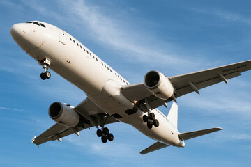Obraz premium White airplane in flight against blue sky