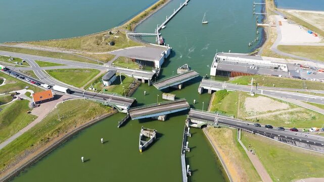 several sailboats navigate through narrow stone walled chambers lorentzsluizen lock complex these paths connect ijsselmeer salt water wadden sea afsluitdijk to netherlands stone-walled 